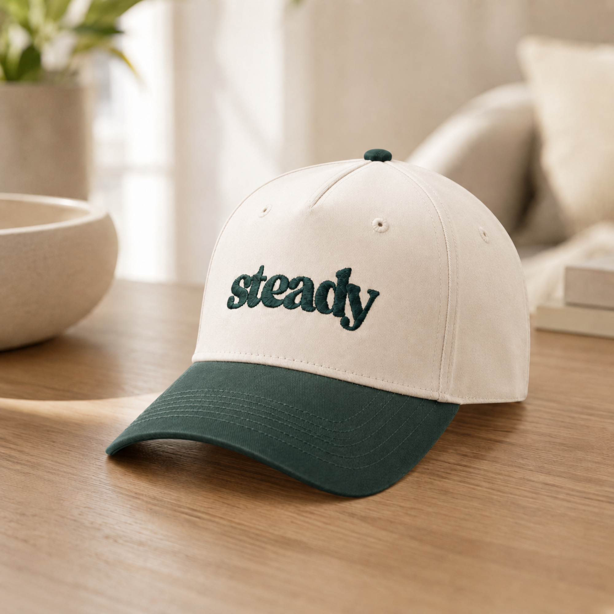 Steady Trucker Hat resting on a wood table in a warm indoor setting.